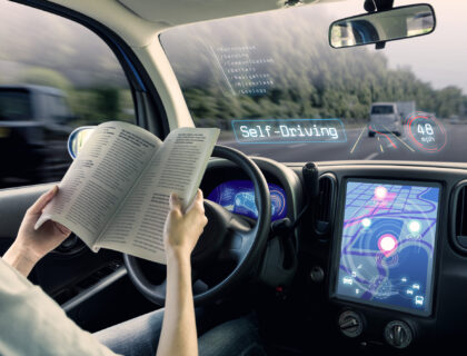 cockpit of autonomous car. a vehicle running self driving mode and a woman driver reading book.